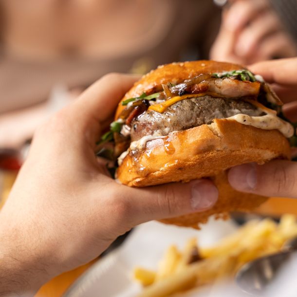 manos sujetando una hamburguesa