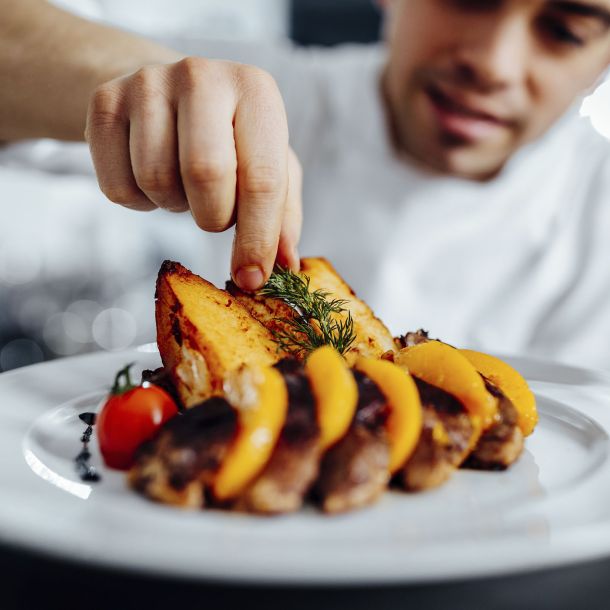 hombre decorando patata asada con romero